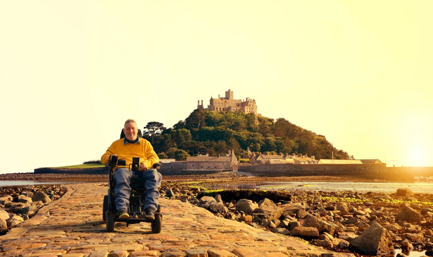 Steven Webb in his electric wheelchair on the causeway to St Michael's Mount, looking out over the water